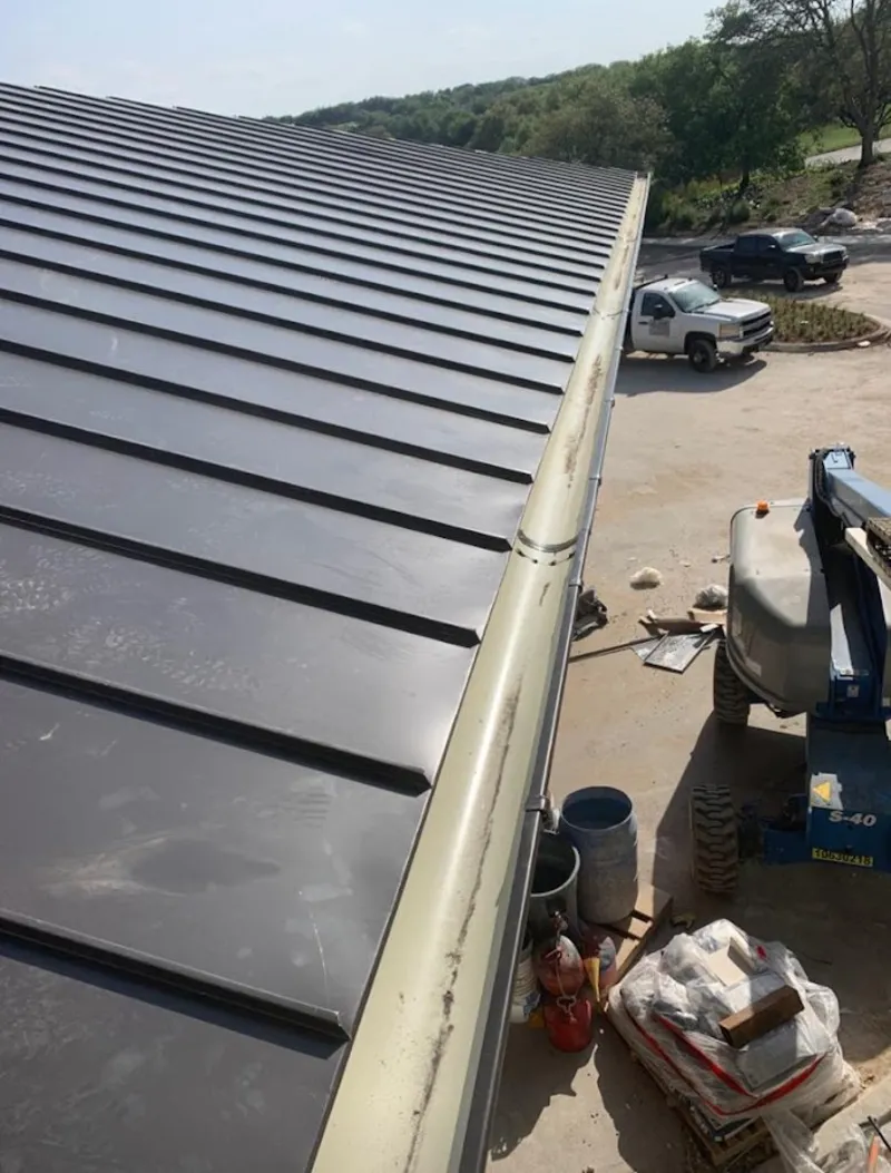 Standing seam panel and gutter detail on a metal roofing jobsite in Canton